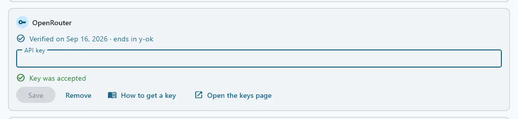 The OpenRouter card after Save: Verified on the date with the key’s last four characters, the box empty again, and a green Key was accepted line under it